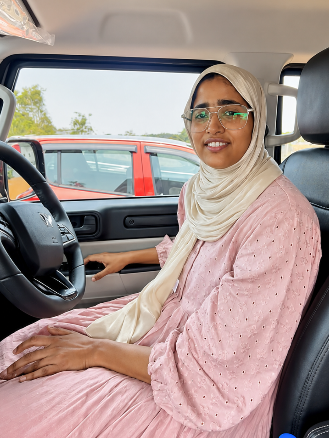 Shamna in the driver's seat of a car