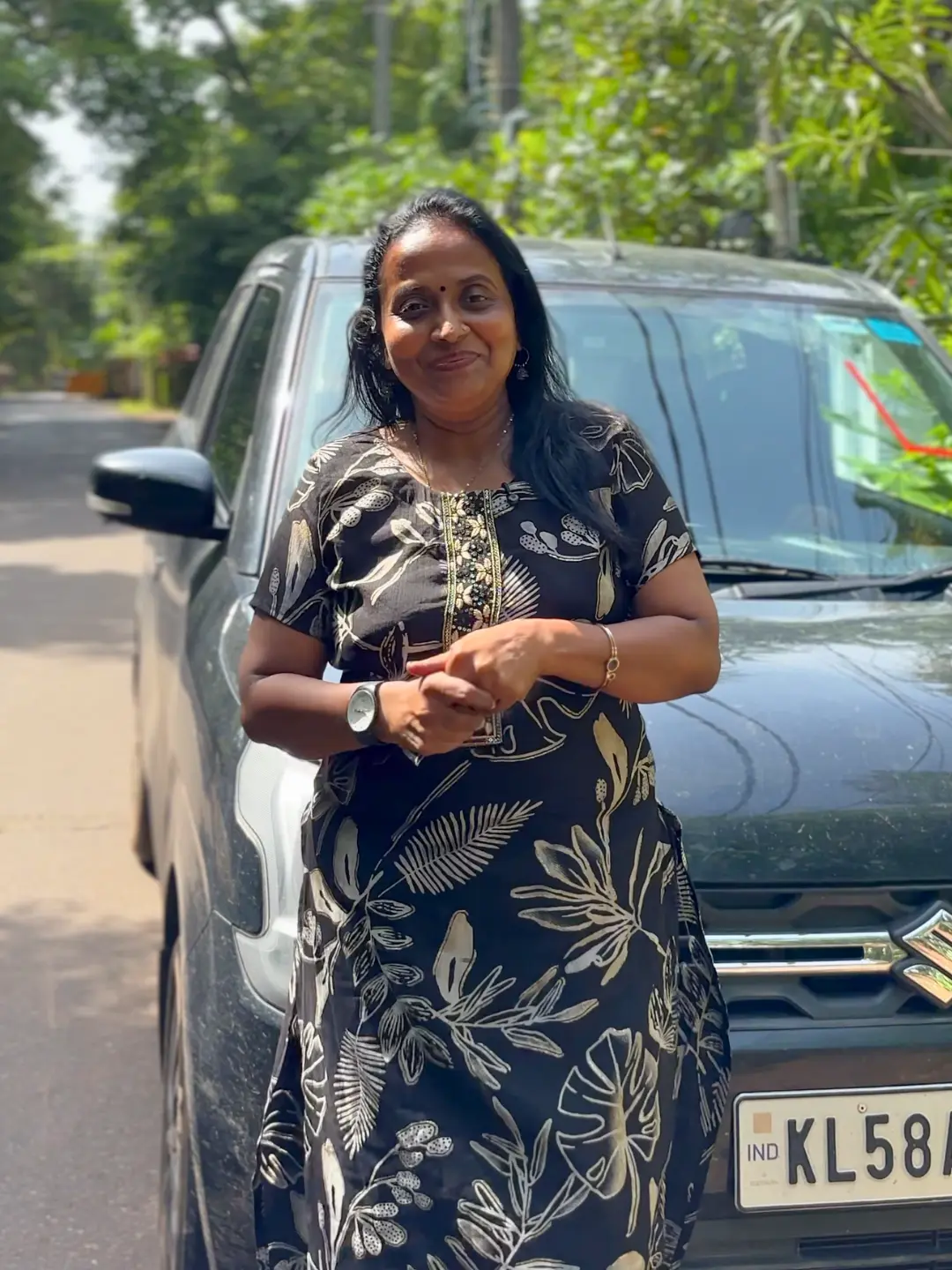 Shajini standing beside a car