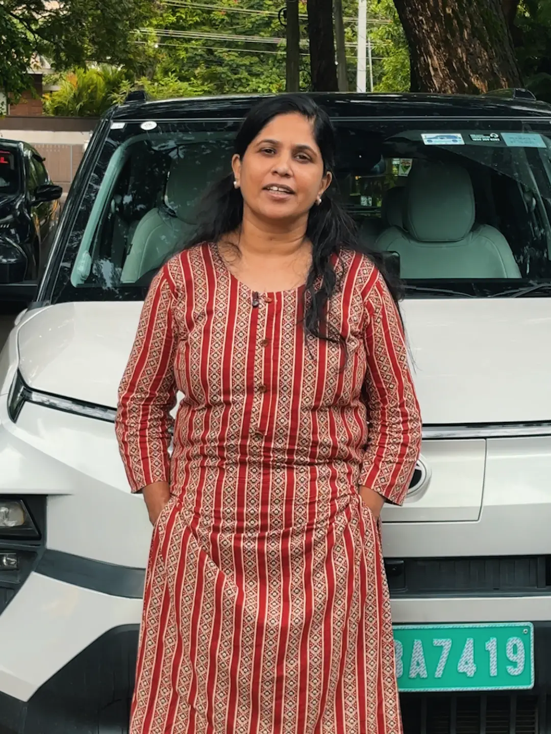Mariyam standing beside a car